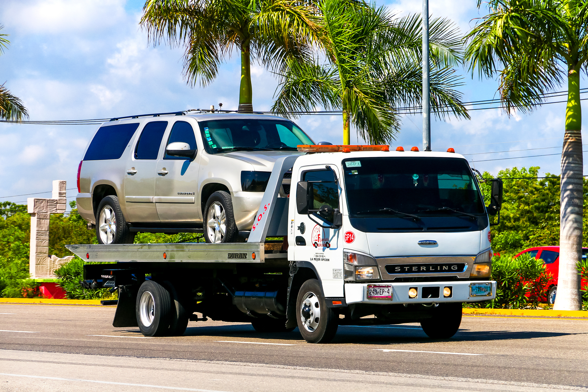 SUV being towed on a flatbed tow truck.