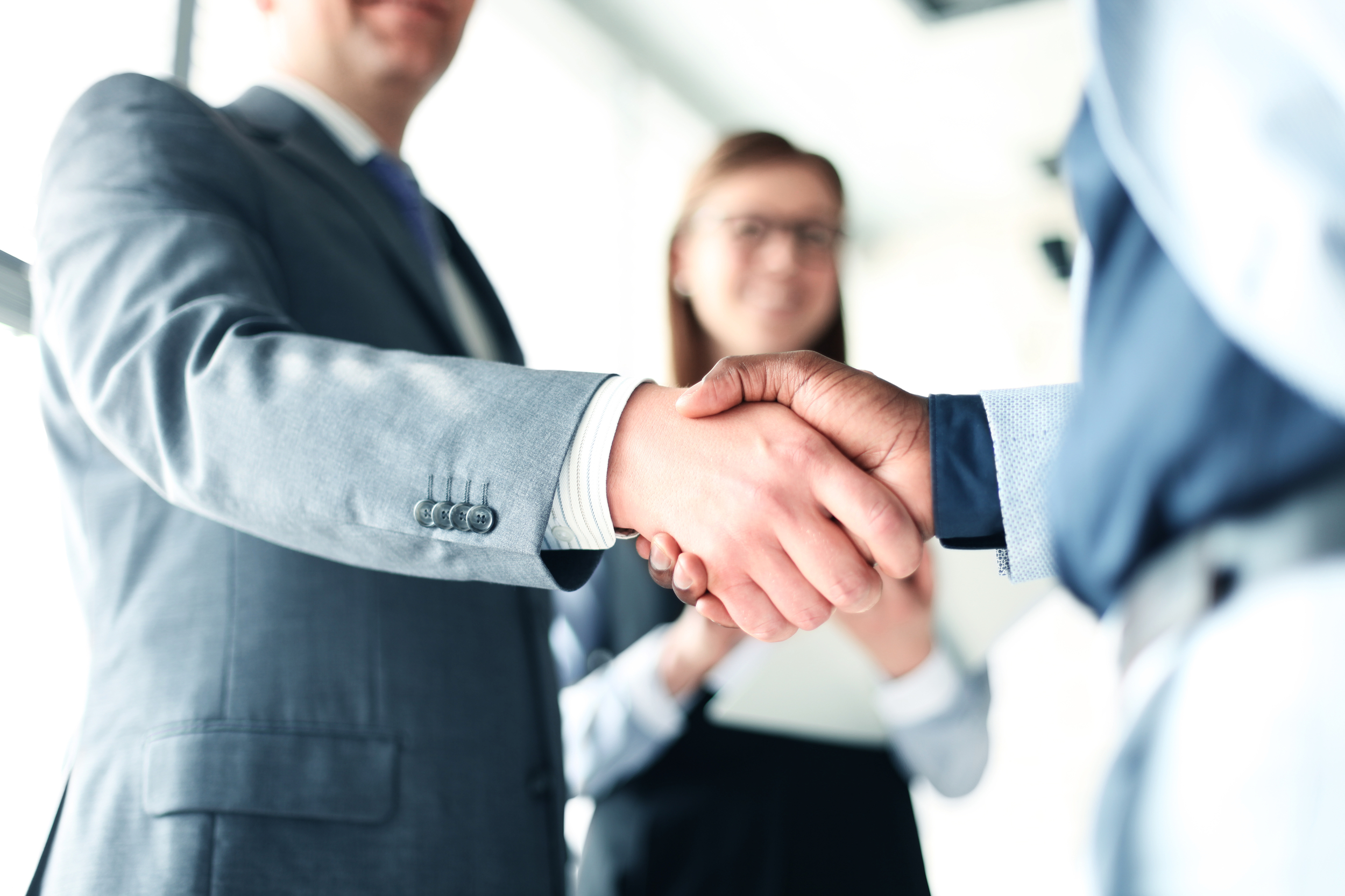 People in suits shaking hands.
